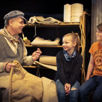Schauspieler spricht mit Kindern im Geschichtenhaus.
