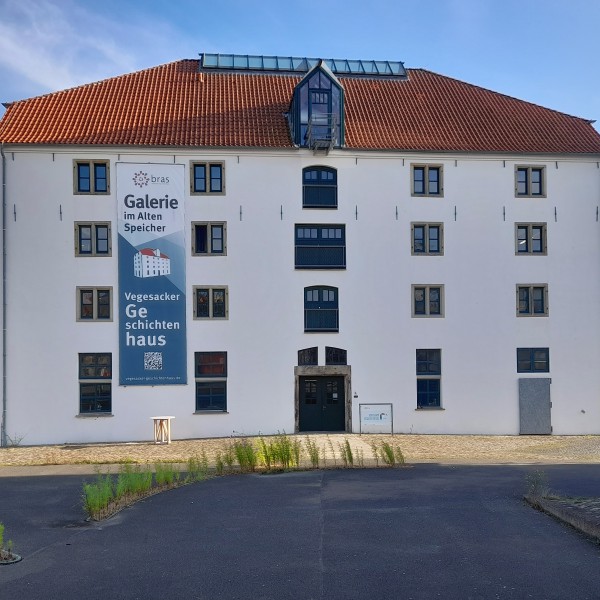 Frontansicht des Alten Speichers mit Bannern für Galerie im Alten Speicher und Vegesacker Geschichtenhaus.